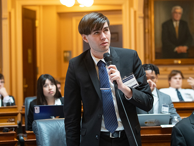 A student speaks into a microphone inside the Virginia State Capitol chambers