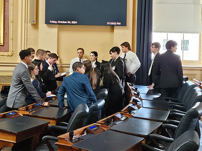 A group of students gathered together in the Virginia State Capitol chambers